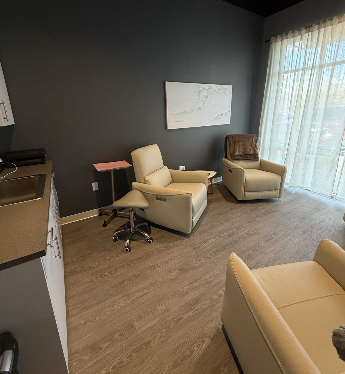 Modern clinic room with recliners and large window